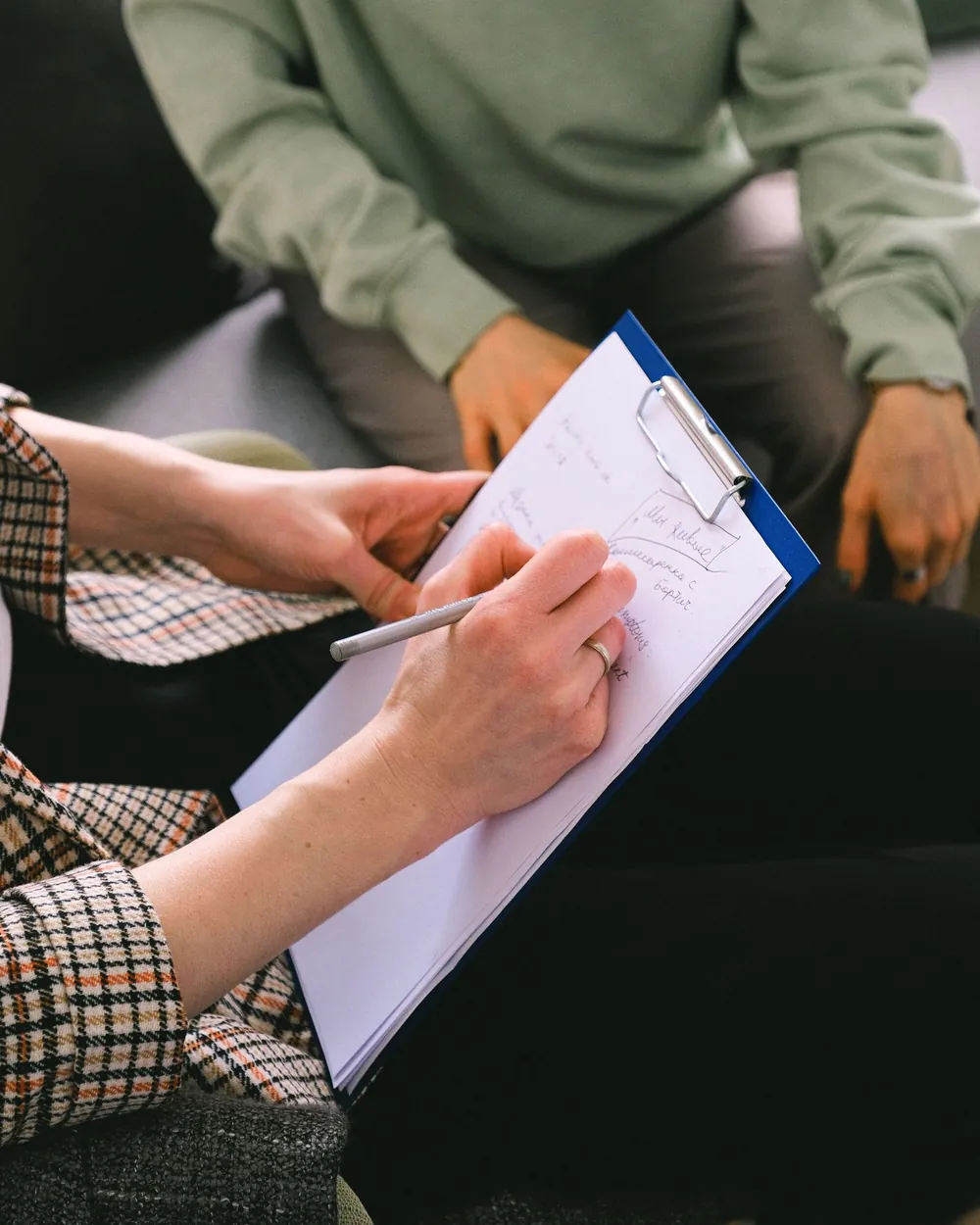 Profesional tomando notas durante una sesión de consulta